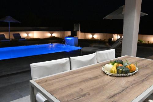 a table with a bowl of fruit on top of it at Villa De An in Zakynthos Town