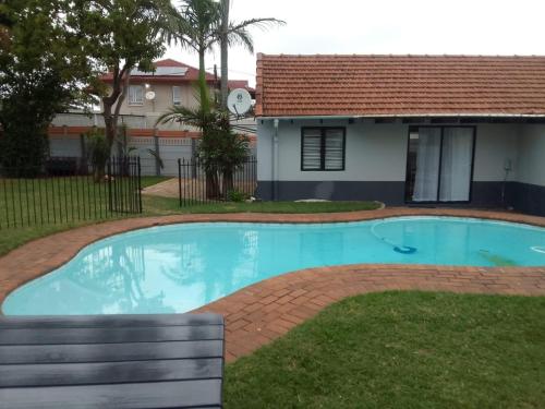 a swimming pool in the yard of a house at Palm Bliss Self Catering Accommodation in Durban