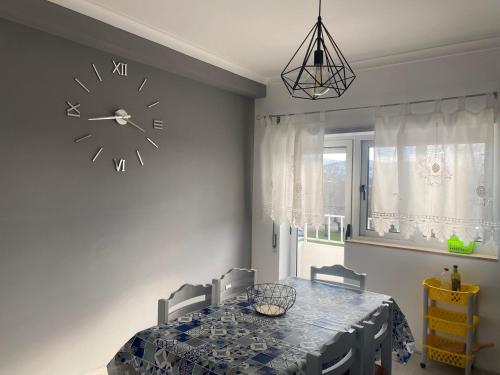 a dining room with a table and a clock on the wall at O Ninho 94 in Vila Praia de Âncora