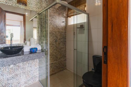 a bathroom with a glass shower with a toilet at Viking Inn - Canto Afetos - Taipú de Fora - Barra Grande - Península de Maraú in Barra Grande