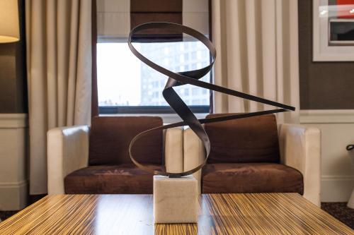 a metal sculpture on a table in front of a chair at The Empire Hotel New York in New York