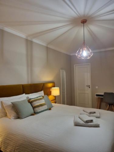 une chambre avec un grand lit avec des serviettes dessus dans l'établissement Diamante house com garagem privada, à Braga