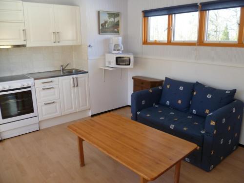 a living room with a blue couch and a table at Röksvamp 3 in Västra Stensjö