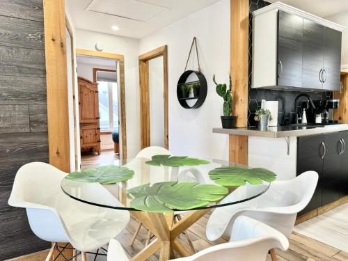 a dining room with a glass table and white chairs at Le Wolfe - 2 Bedrooms - 2 min Falls - Free Parking in Boischâtel