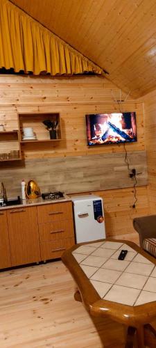 a kitchen with a table and a tv on the wall at mood villa kazbegi in Kazbegi