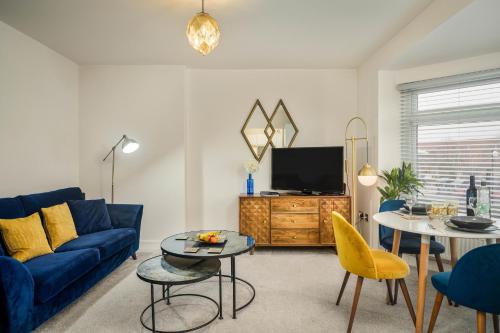 a living room with a blue couch and a tv at Coppergate Mews Doncaster Apartment 4 in Doncaster