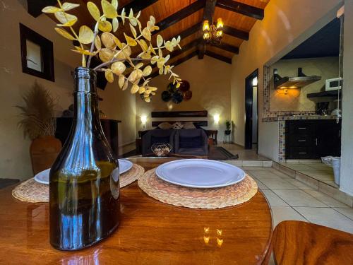 a bottle of wine sitting on a table with a plate at Cabañas Las Morenas Mazamitla in Mazamitla