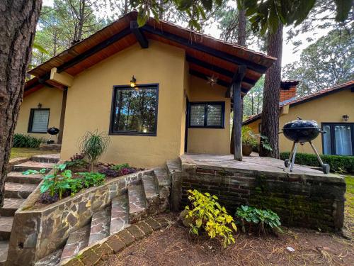 a house with a stone retaining wall and a porch at Cabañas Las Morenas Mazamitla in Mazamitla