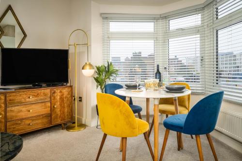 a dining room with a table and chairs and a television at Coppergate Mews Doncaster Apartment 4 in Doncaster