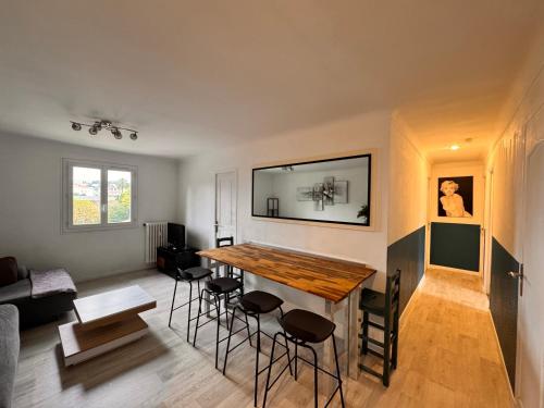- un salon avec une table et des chaises en bois dans l'établissement Spacieux/paisible 5 pièces en plein coeur de Nice, à Nice