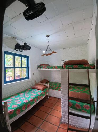 a room with two bunk beds and a window at Hostel Terra das Tribos in Ubatuba