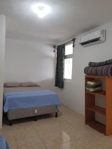 Un dormitorio pequeño con una cama y una ventana. en Casa María Victoria, en Taxisco