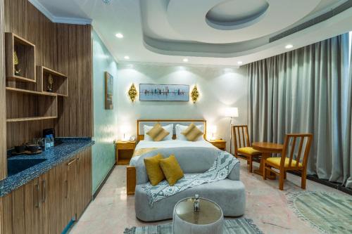 ジッダにあるBlue star hotelのベッドとテーブルと椅子のある寝室