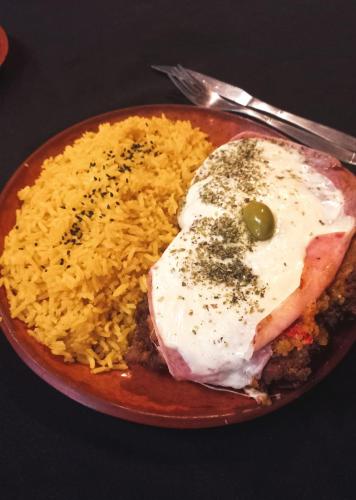 a plate of food with meat and rice on a table at El Caucillar in Iruya