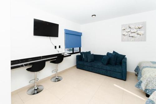 a living room with a blue couch and a desk at Apartamentos Torre II Condominios - Pet Friendly in Mazatlán