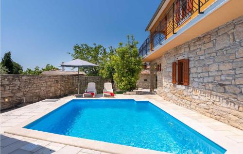 une piscine avec deux chaises et une maison dans l'établissement Villa Zaneta, à Vošteni