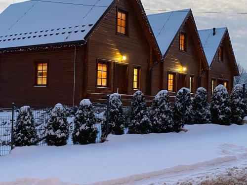 ein Holzhaus mit Schnee auf dem Boden in der Unterkunft DOMKI NA WCZASOWEJ in Szczyrk