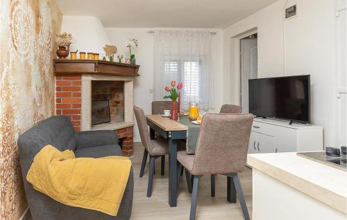 eine Küche und ein Wohnzimmer mit einem Tisch und einem TV in der Unterkunft Awesome Home In Nedescina With Wifi in Nedeščina
