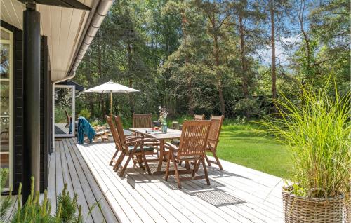 a deck with a table and chairs and an umbrella at Stunning Home In Sjællands Odde in Yderby