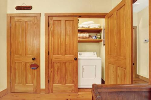 a kitchen with wooden doors and a washer and dryer at Family Friendly Cottage 9 Logan in Tybee Island