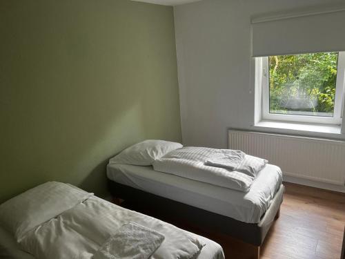two beds in a small room with a window at Hami Apartments Hannover in Hannover