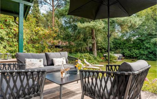 a patio with a couch and a table and an umbrella at 3 Bedroom Gorgeous Home In Gilleleje in Gilleleje