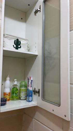 a bathroom shelf with a sink and a mirror at Garden Room in Nzamata