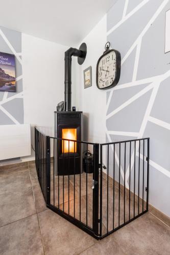 - une cheminée dans une pièce dotée d'une horloge murale dans l'établissement Dodo Normand 3 chambres bedrooms - Poêle à granulés - Linge - Ménage - Inclus, à Villedieu-les-Poêles