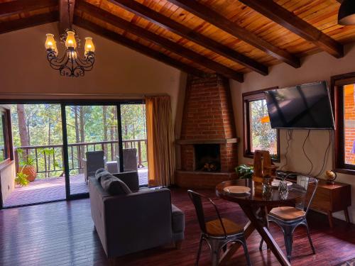 a living room with a couch and a table and a fireplace at Cabañas Las Morenas Mazamitla in Mazamitla