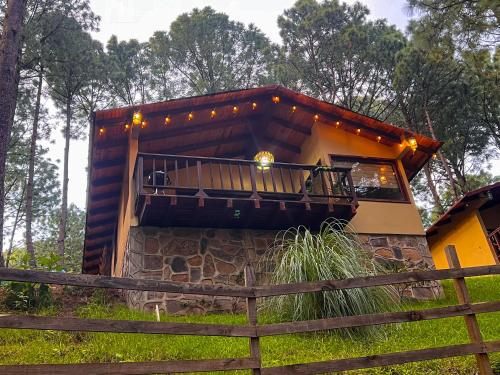 a house with a balcony with lights on it at Cabañas Las Morenas Mazamitla in Mazamitla