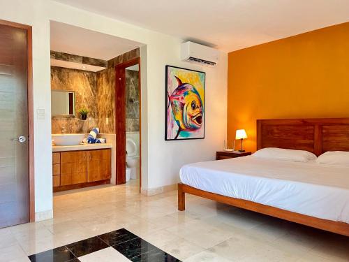a bedroom with a bed and a bathroom at studio au coeur de la marina in Puerto Aventuras