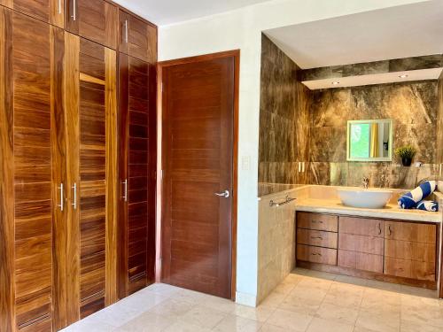 La salle de bains est pourvue de portes en bois et d'un lavabo. dans l'établissement studio au coeur de la marina, à Puerto Aventuras