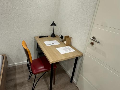 a desk with a red chair next to a door at City Apart 3 Stadtwohnung mit NETFLIX Nahe Bahnhof in Sinsheim