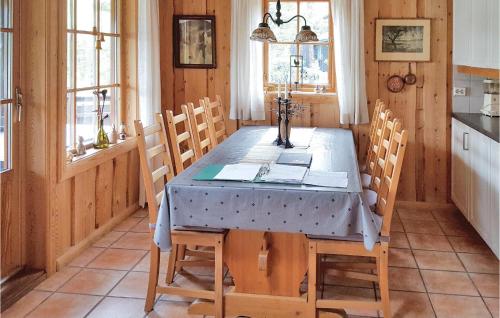 a dining room with a table with chairs and windows at Hytte Nr 4-156 in Frafjord