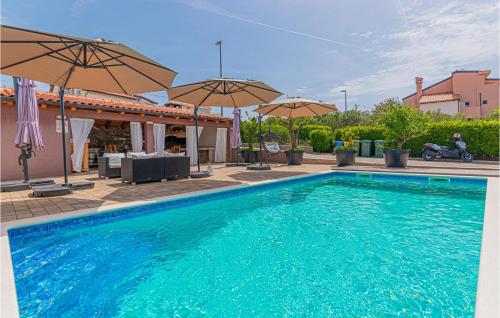 a swimming pool with two umbrellas and a motorcycle at Lovely Home In Brodarica With Jacuzzi in Brodarica