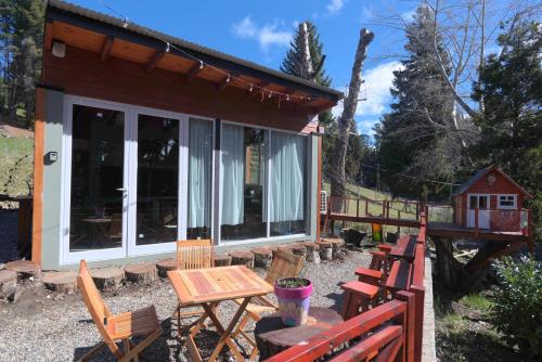 a cabin with a table and chairs in front of it at Amutuy Bariloche in San Carlos de Bariloche