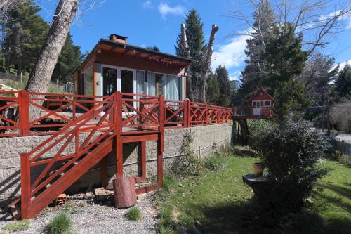 a small house with a red fence and a bridge at Amutuy Bariloche in San Carlos de Bariloche