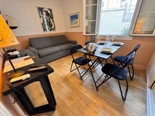 un salon avec une table, des chaises et un canapé dans l'établissement Peaceful Flat w WiFi Very Close to Pl Massena Refurbished, à Nice