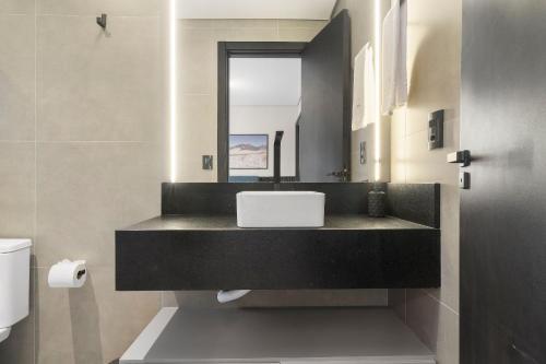 a bathroom with a sink and a mirror at Res. Tribeca 350m Rua Coberta by Achei Gramado in Gramado