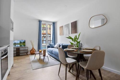 un salon avec une table et un canapé bleu dans l'établissement Appartement Chaville - Parking - Proche Paris, à Chaville