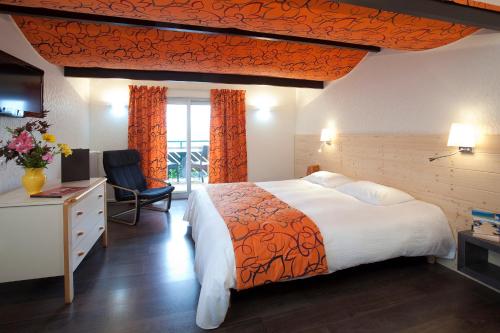 a hotel room with a large bed and a window at Logis Hôtel Clair Matin in Le Chambon-sur-Lignon