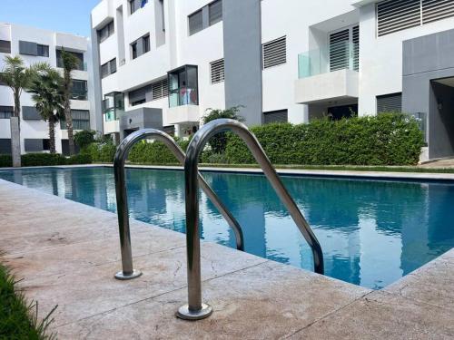 a swimming pool in front of a building at Appartement Les pieds dans l'eau in Oulad Kerroum