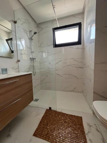 a bathroom with a shower and a sink and a toilet at Appartement Les pieds dans l'eau in Oulad Kerroum