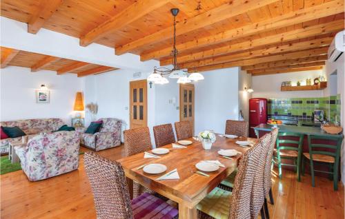 a dining room and living room with a wooden table and chairs at Holiday Home Prolozac Donji 12 in Donji Proložac