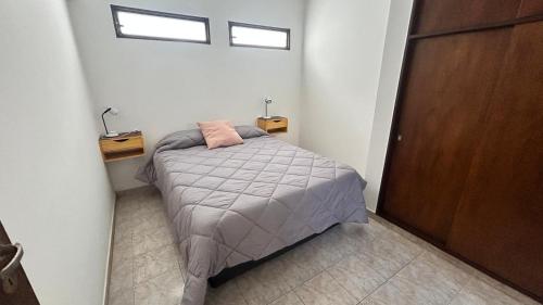 a small bedroom with a bed and a window at 760 C Apartamentos in Alta Gracia