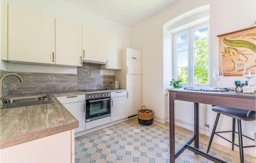 a kitchen with white cabinets and a table and a window at Ferienwohnung Im Erdgeschoss in Persenbeug-Gottsdorf