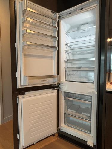 an empty refrigerator with its door open in a kitchen at Waterfront luxury living - Wynyard Quarter in Auckland