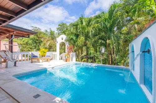 a swimming pool in a yard with palm trees at Casa Vitality Bed and Breakfast - Playa Guiones, Nosara - 4 Minute Walk to the Beach in Nosara