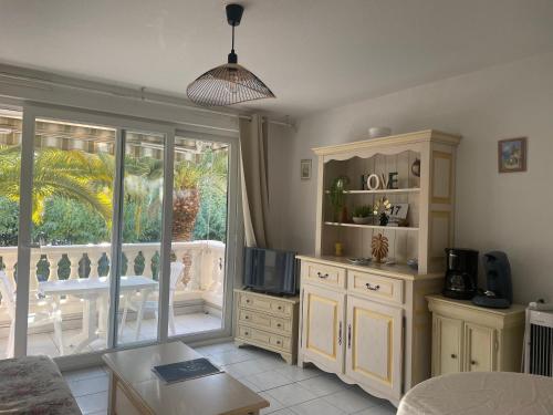 un salon avec un canapé, une télévision et une table dans l'établissement Le Tropical - 4 Pers - Ensoleillé, à Fréjus