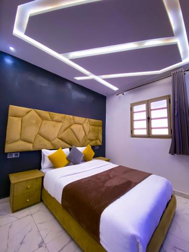 a bedroom with a large bed and a blue wall at Equinox in Tan-Tan Plage